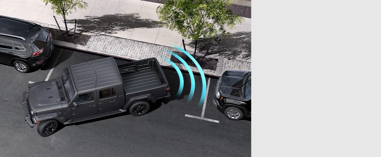 The 2021 Jeep Gladiator High Altitude with illustrated sensors monitoring the area behind the rear bumper, detecting the curb as it parallel parks.