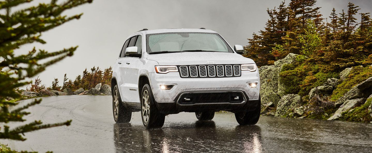 The 2021 Jeep Grand Cherokee Overland being driven on a wet street in the rain.