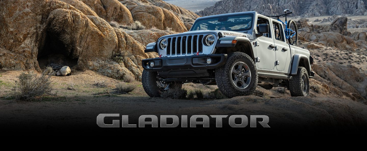 The 2022 Jeep Gladiator Rubicon towing an enclosed trailer on a snowy mountain road. The Presidents Day Event logo.